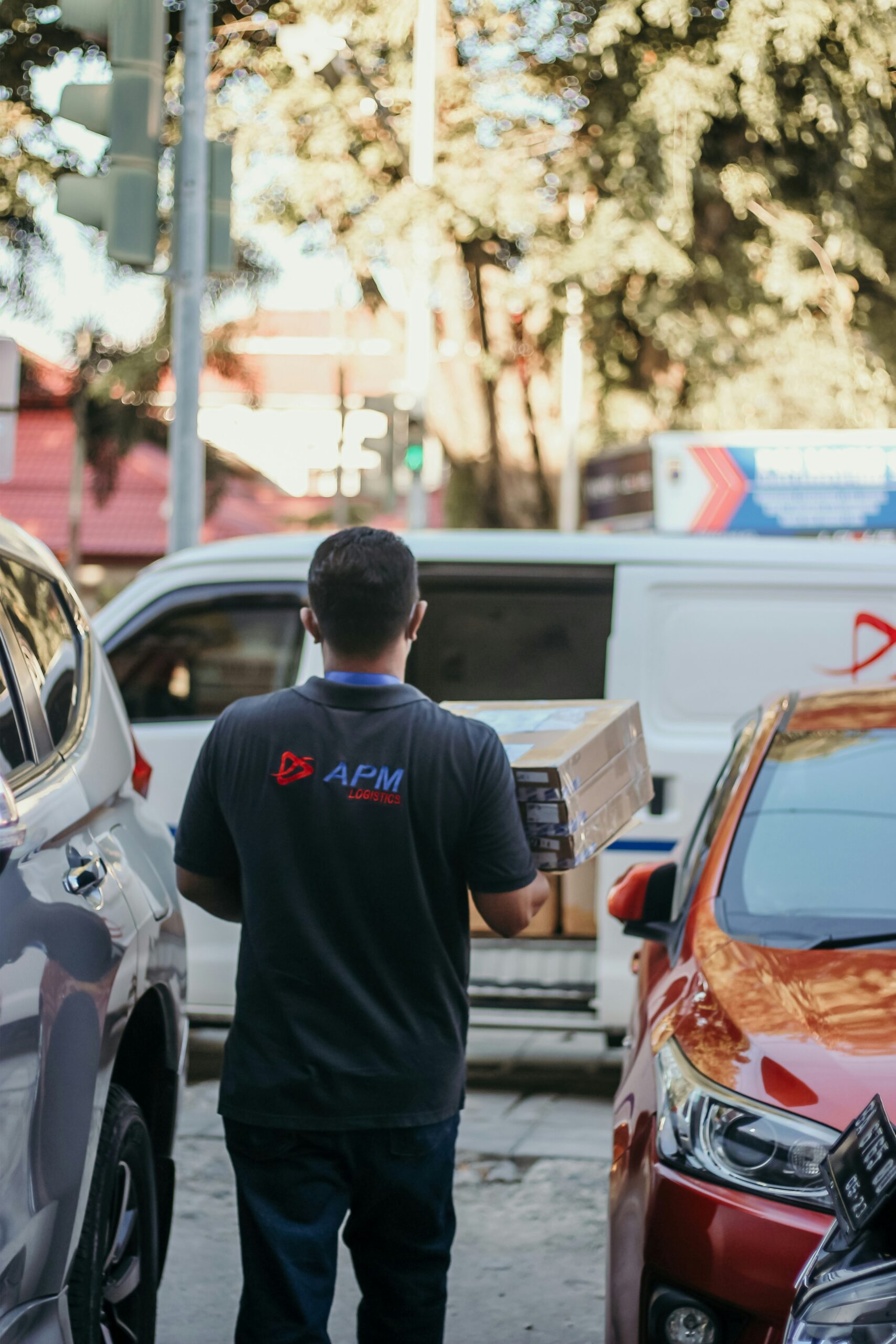 a man walking down a street next to parked cars